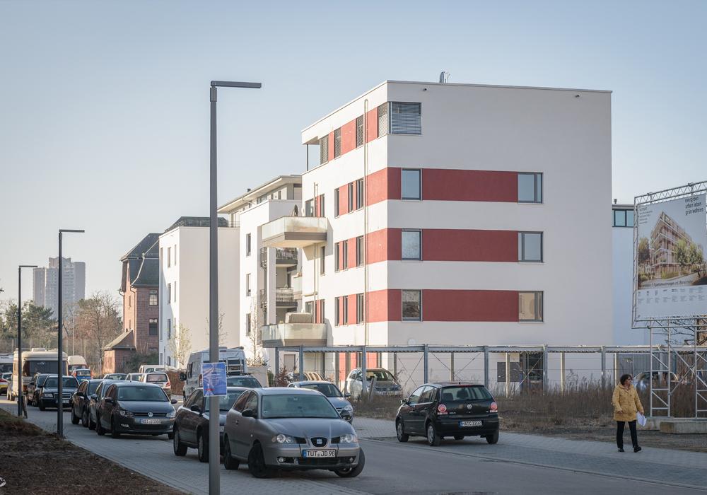 Kräftig rote Putzstreifen nehmen die Sandsteintöne der Umgebung auf.